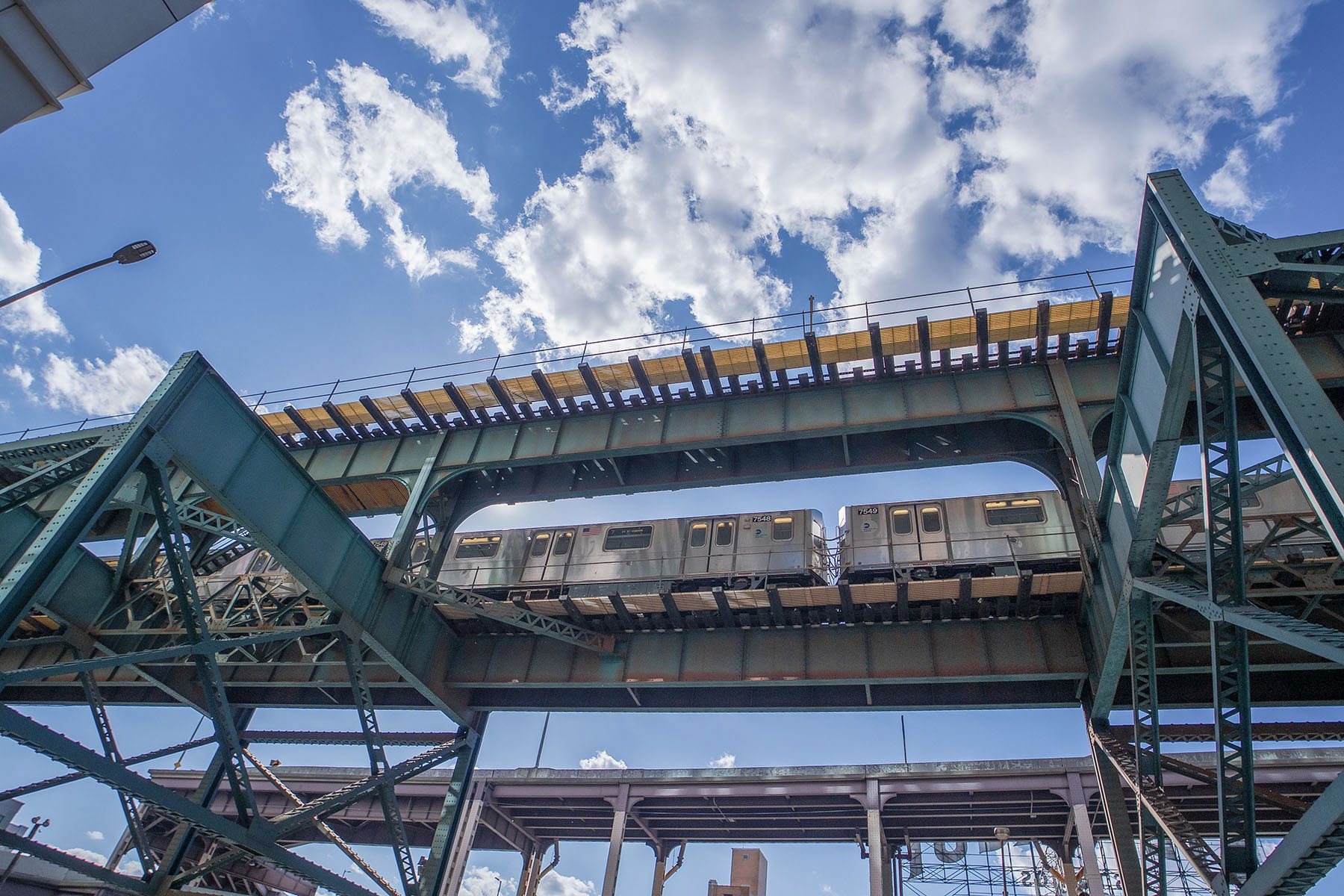 An elevated subway train passing through the steel structure at Queensboro Plaza